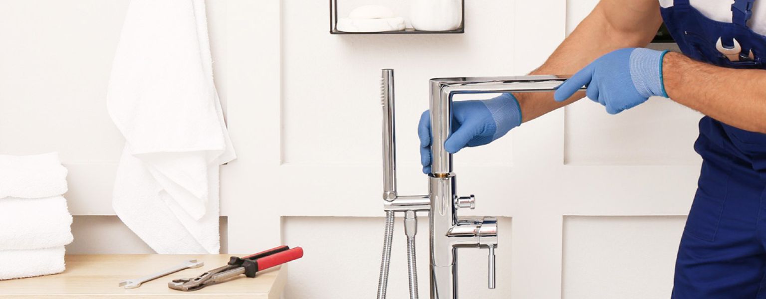 Plumber fixing tap in bathroom John G. Plumbing Drain and Sewer Cleaning