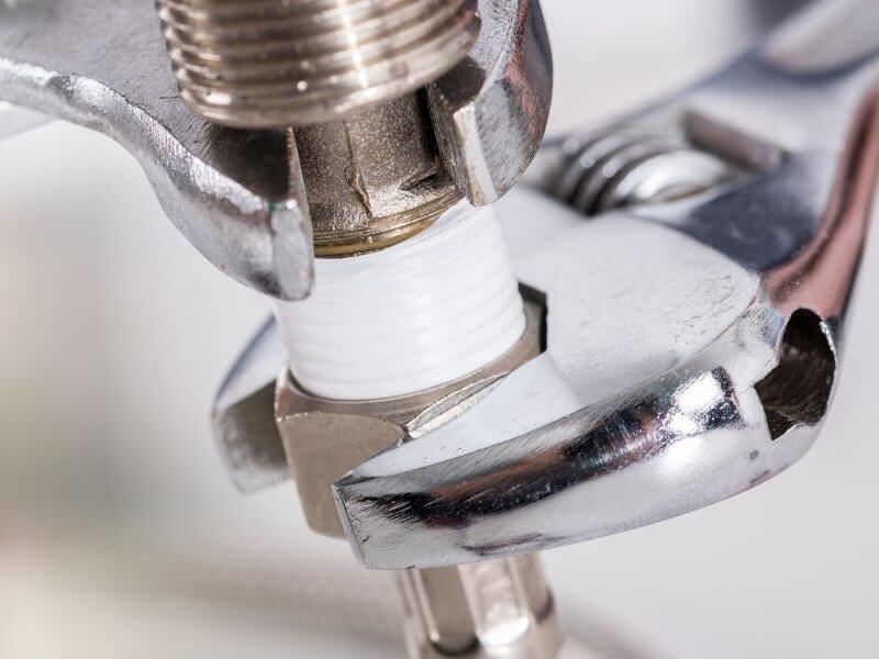 Plumber fixing tap in bathroom John G. Plumbing Drain and Sewer Cleaning