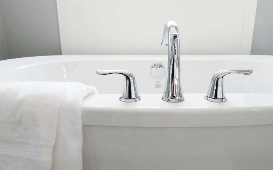 A clean, white bathtub with a white towel.