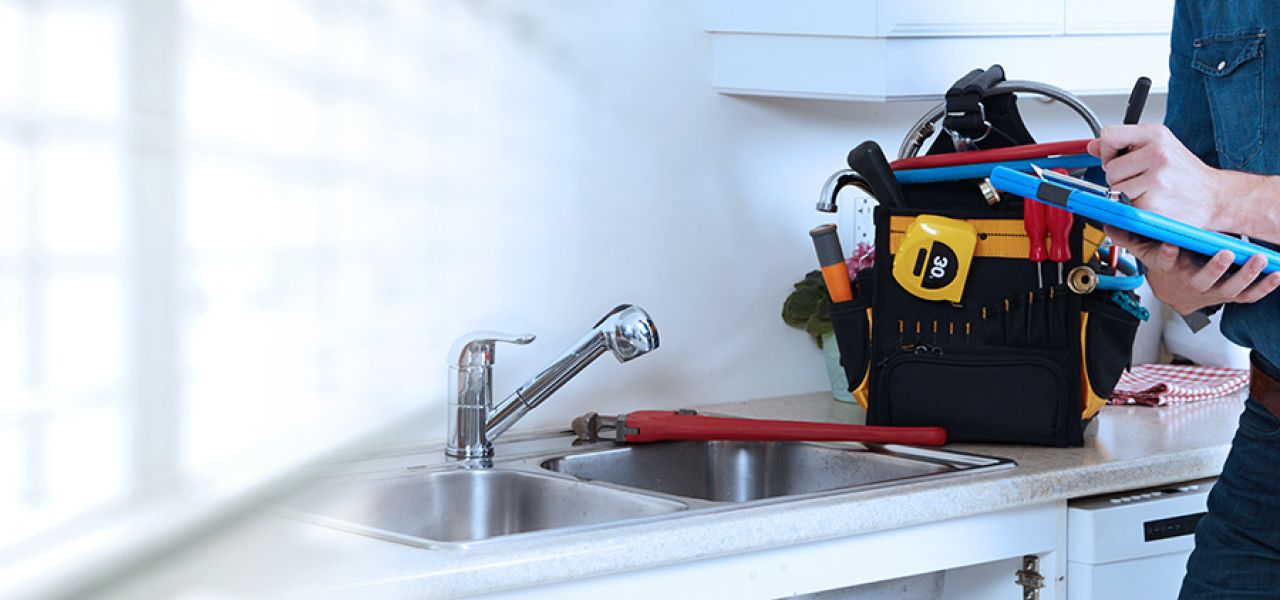 John G. Plumbing plumber with tools at house writing on clipboard