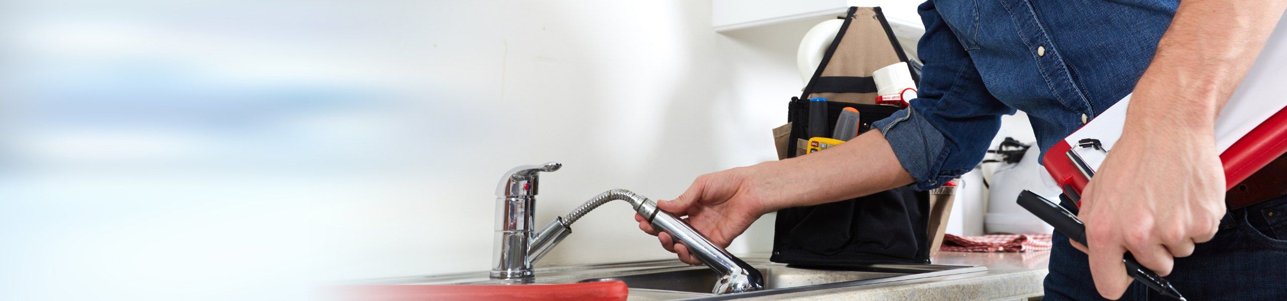 Plumber fixing tap in kitchen John G. Plumbing Gas and Plumbing Tips and News