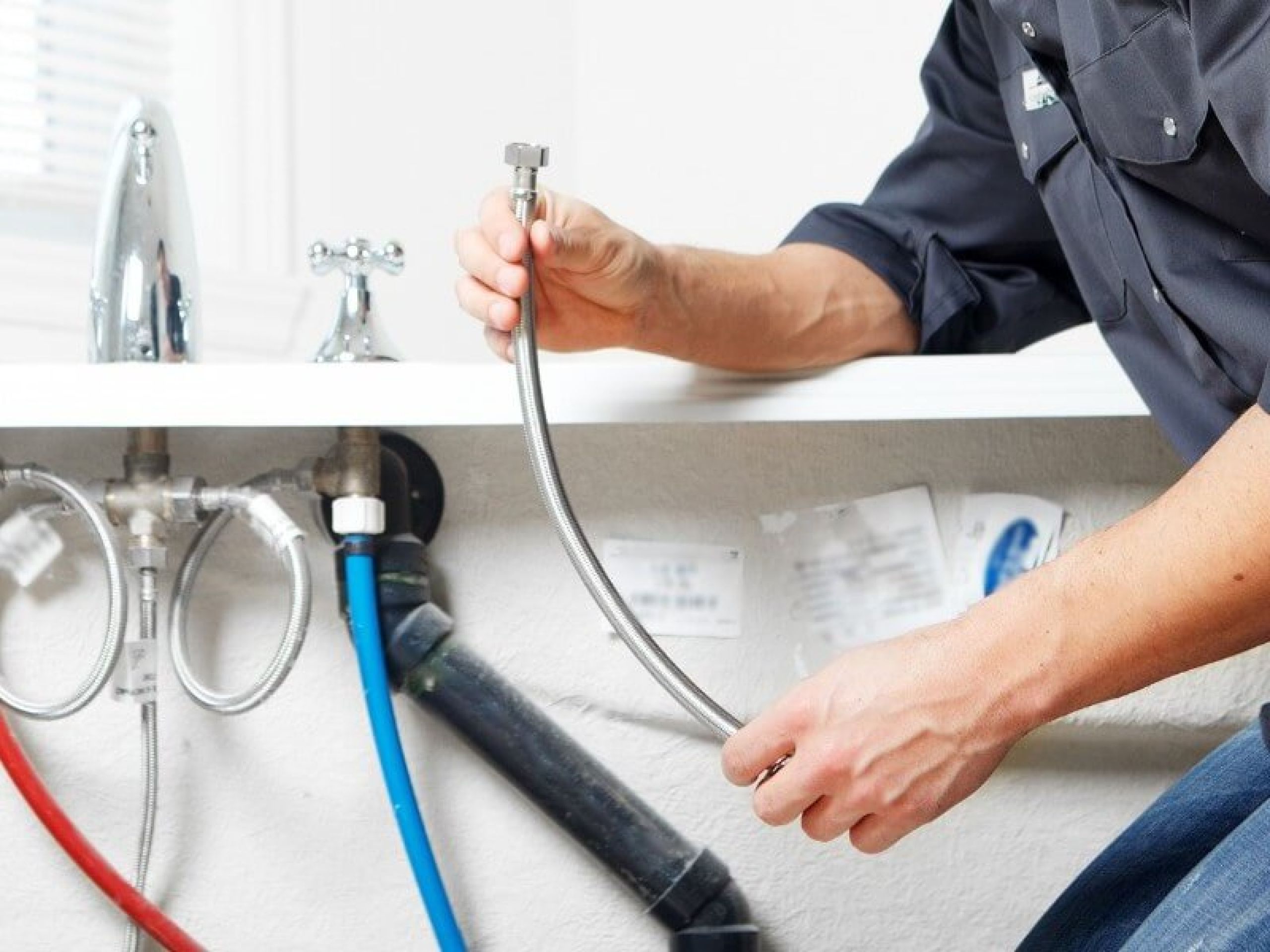 Plumber fixing tap in bathroom John G. Plumbing Drain and Sewer Cleaning