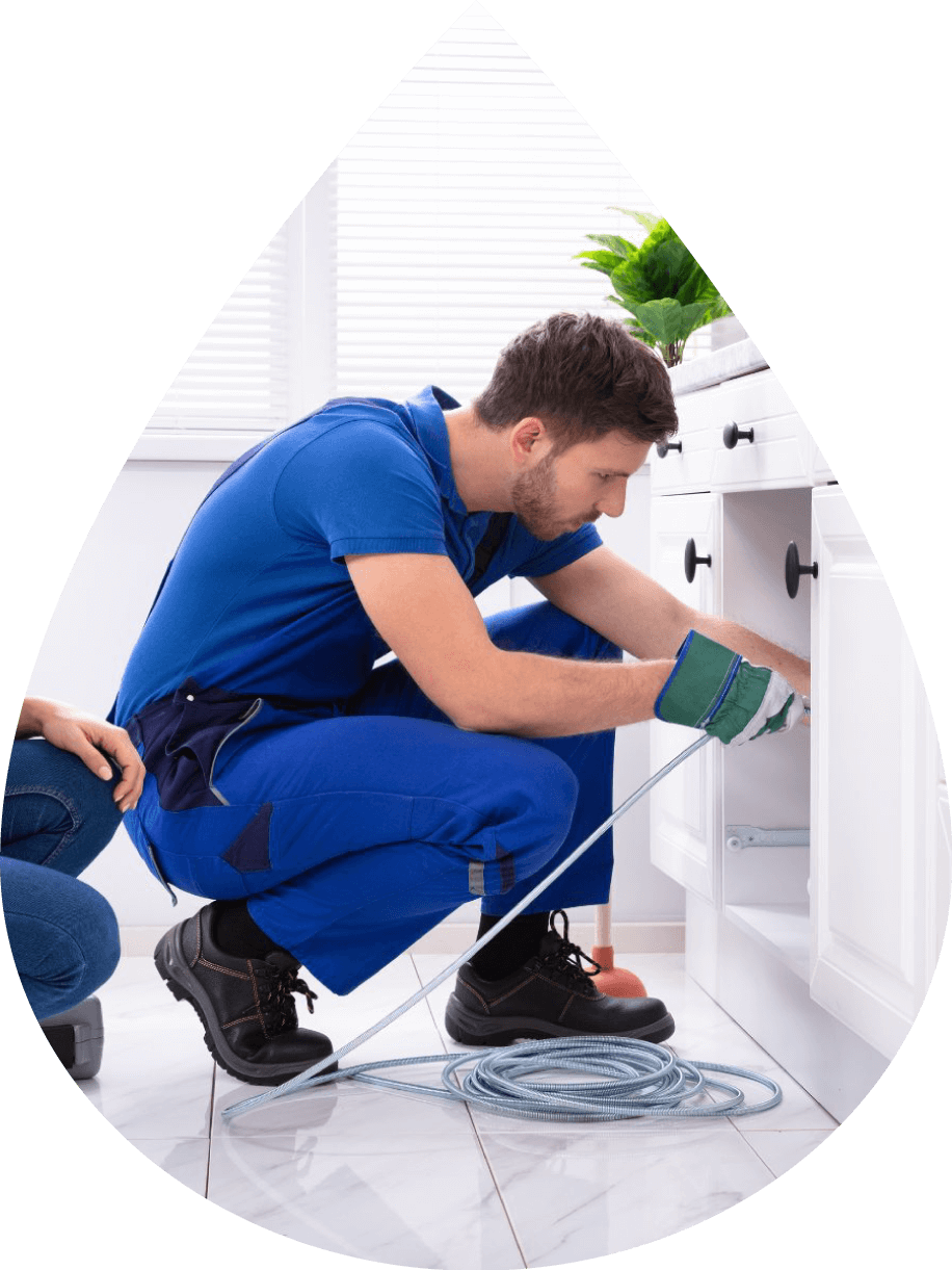 Plumber working on kitchen sink John G. Plumbing Drain and Sewer Cleaning