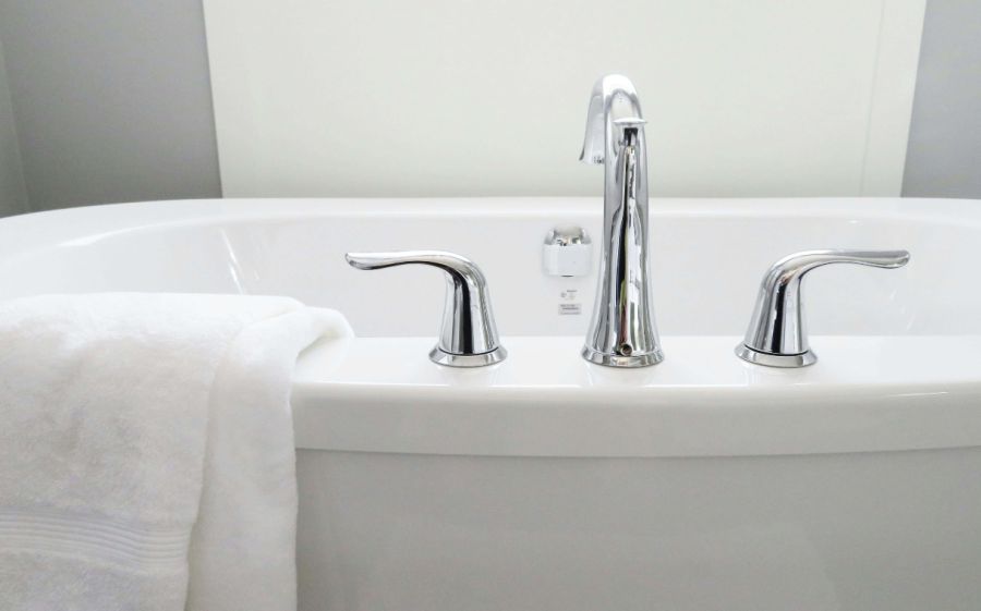 A clean, white bathtub with a white towel.