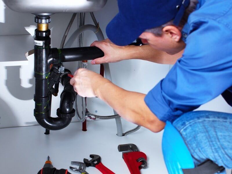 Plumber fixing tap in bathroom John G. Plumbing Drain and Sewer Cleaning