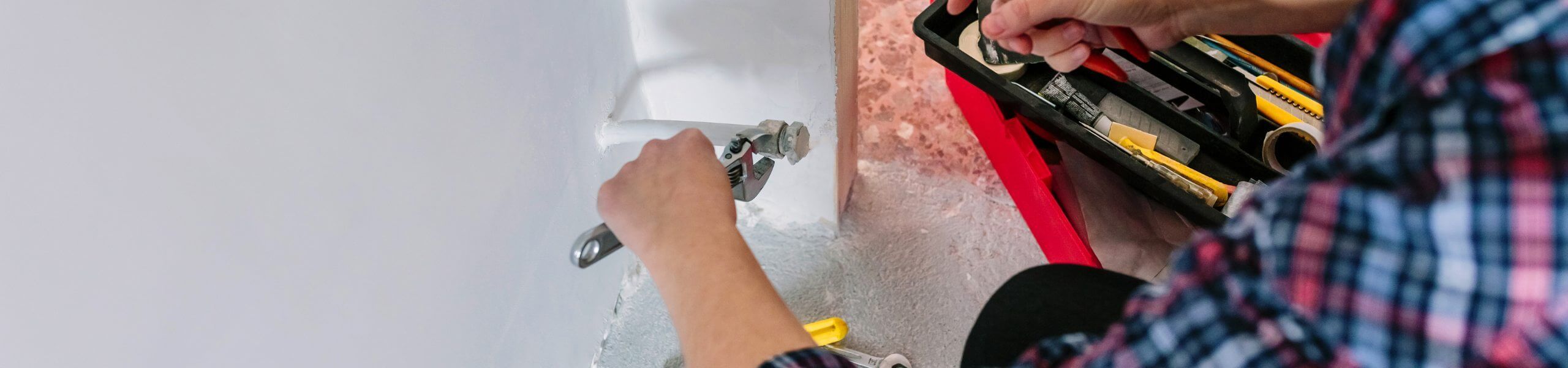 Plumber fixing tap in bathroom John G. Plumbing Drain and Sewer Cleaning