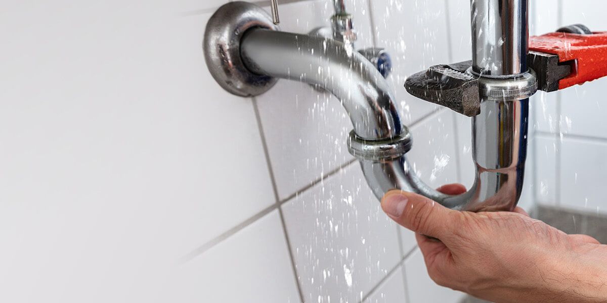 Plumber fixing tap in bathroom John G. Plumbing Drain and Sewer Cleaning