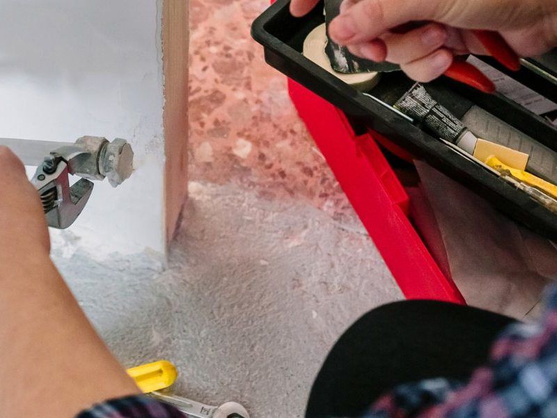 Plumber fixing tap in bathroom John G. Plumbing Drain and Sewer Cleaning