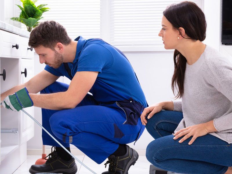 Plumber fixing tap in kitchen for client John G. Plumbing Testimonials