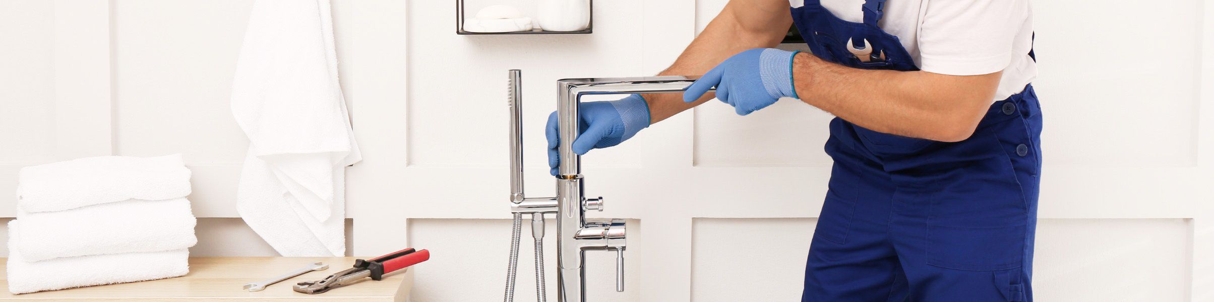 Plumber fixing tap in bathroom John G. Plumbing Drain and Sewer Cleaning