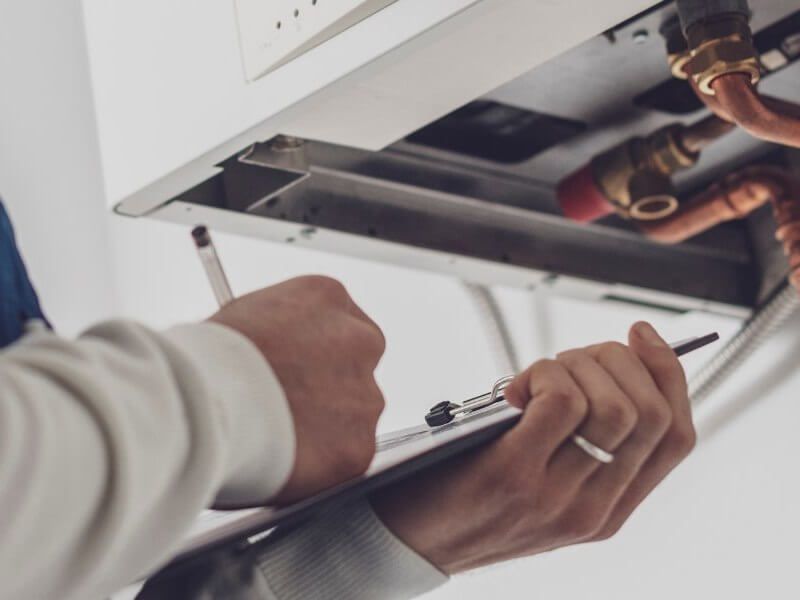 Plumber fixing tap in bathroom John G. Plumbing Drain and Sewer Cleaning