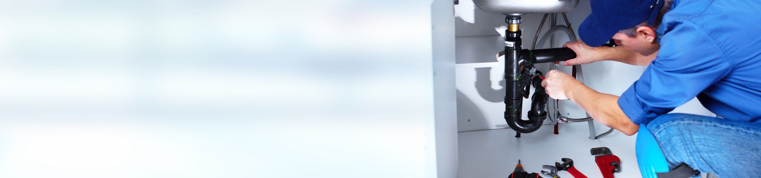 Plumber fixing tap in bathroom John G. Plumbing Drain and Sewer Cleaning