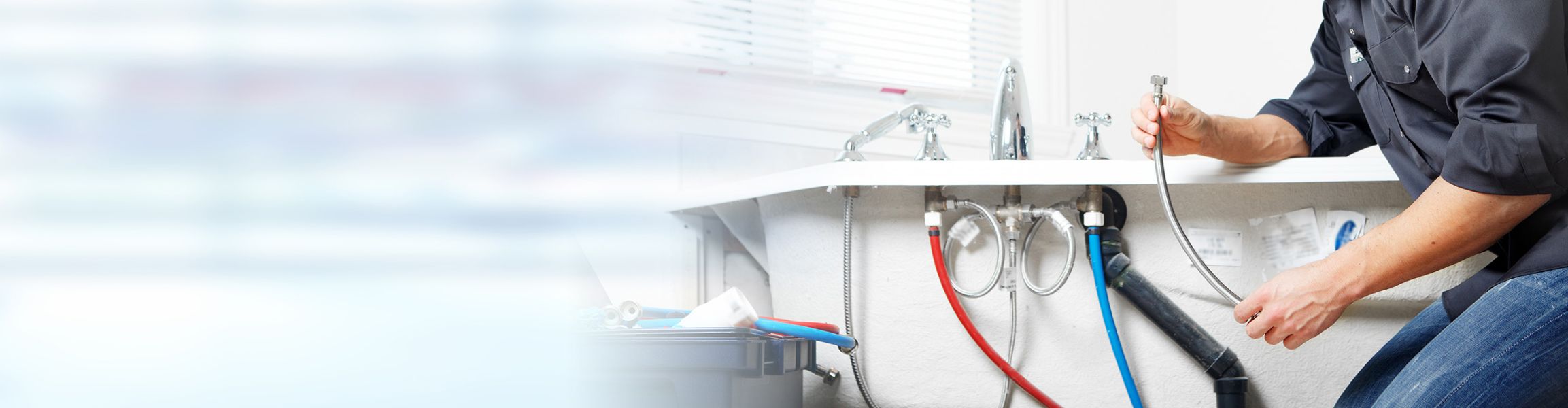 Plumber fixing tap in bathroom John G. Plumbing Employment Opportunity