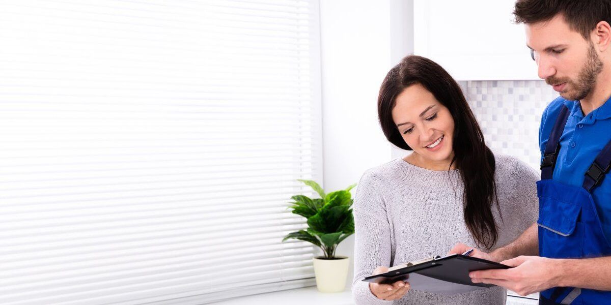 Plumber fixing pipe under sink John G. Plumbing Coombs