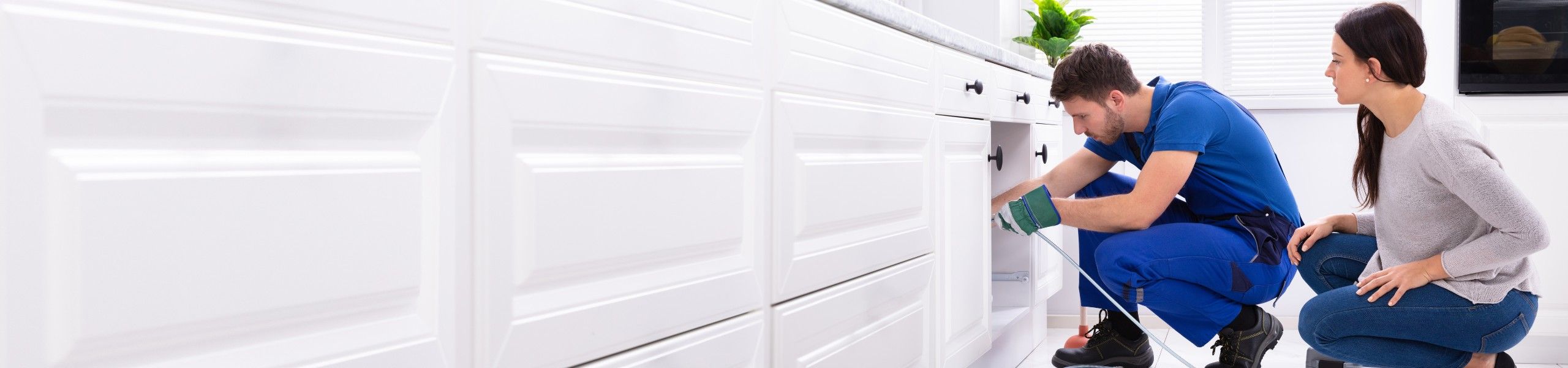 Plumber fixing tap in kitchen for client John G. Plumbing Testimonials