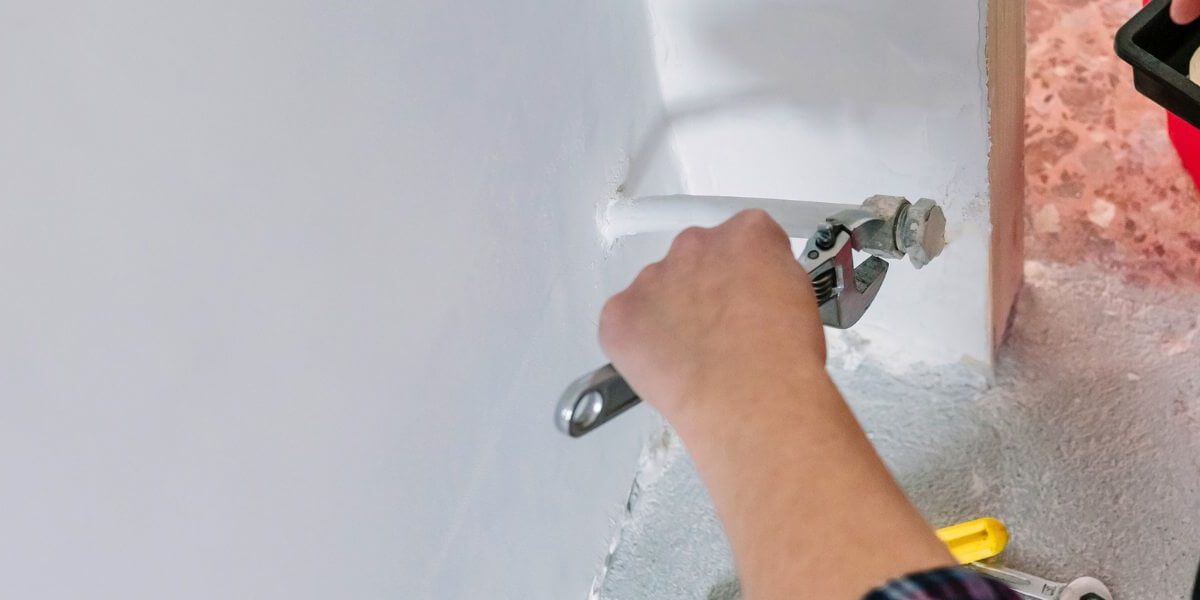 Plumber fixing tap in bathroom John G. Plumbing Drain and Sewer Cleaning