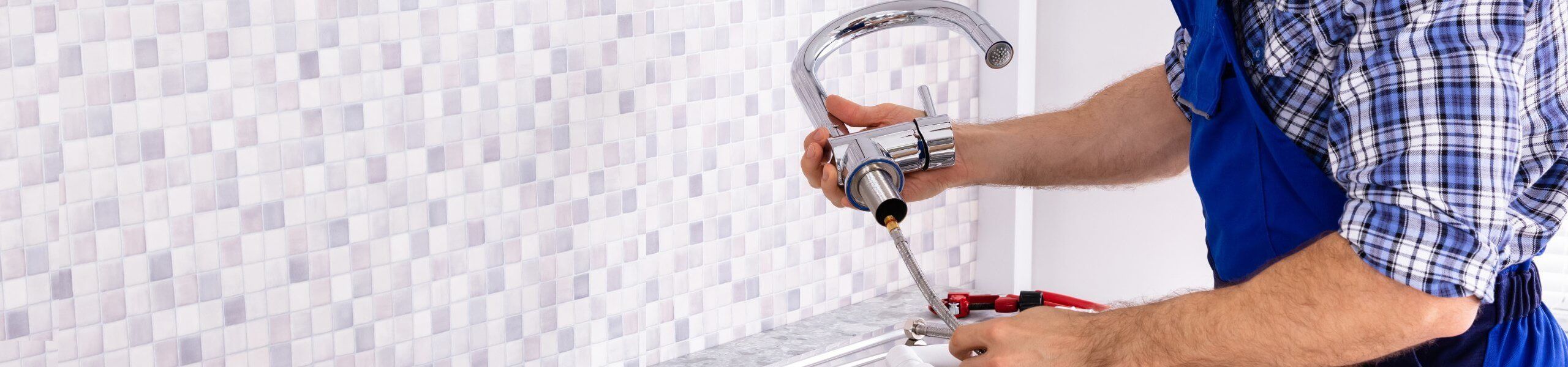 Plumber fixing tap in bathroom John G. Plumbing Drain and Sewer Cleaning